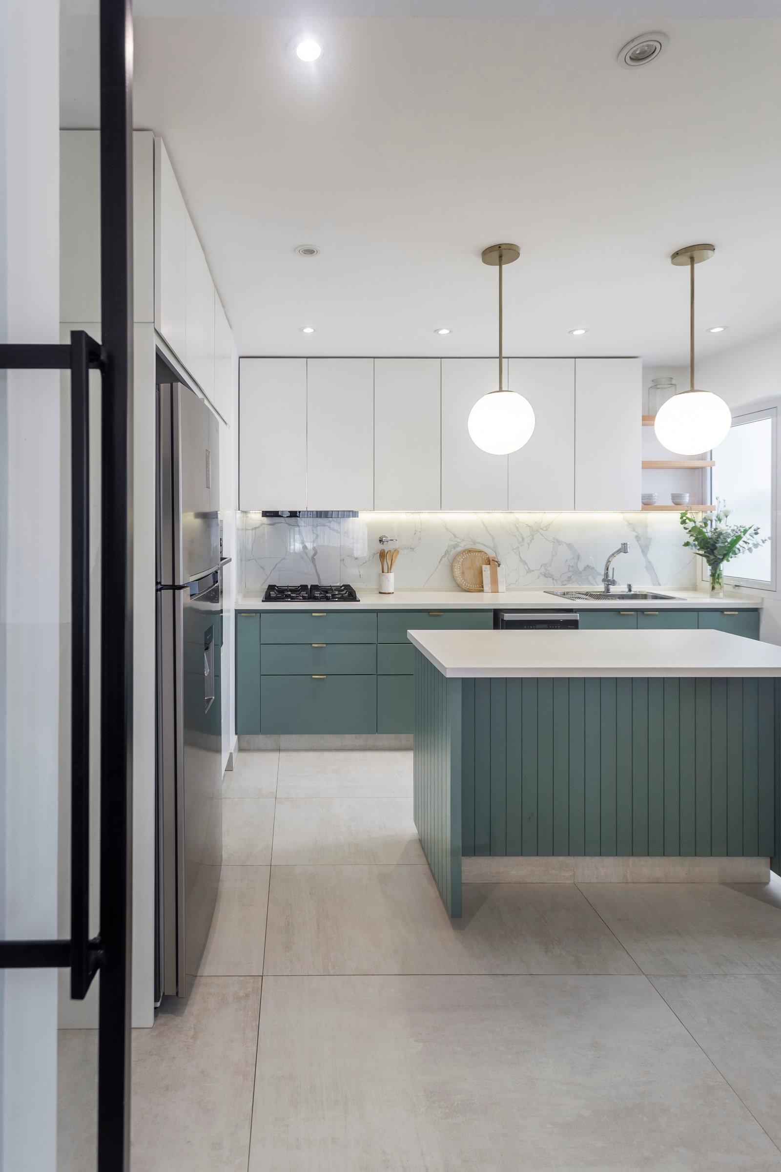 Cocina moderna con isla verde, luces colgantes y acabados de mármol — proyecto La Pampa, por JT ARQUITECTURA, en Buenos Aires