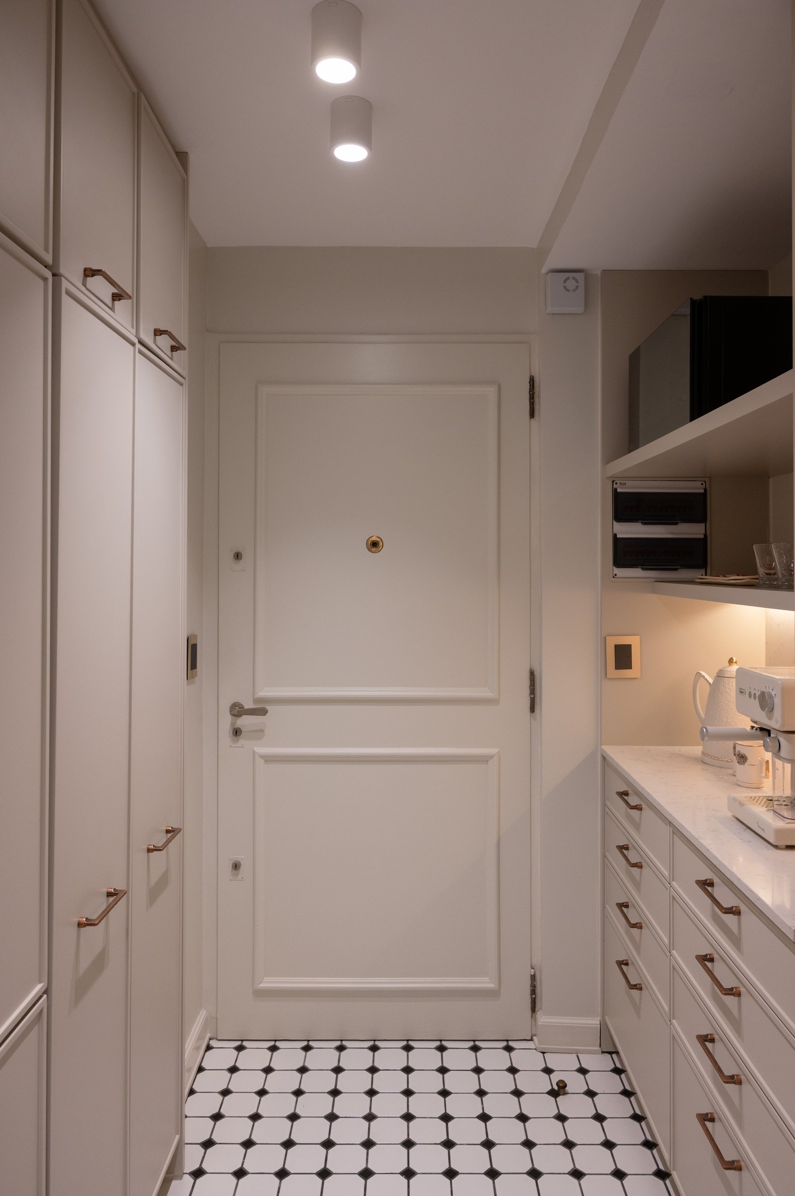 Pasillo estrecho con puerta blanca y baldosas geométricas — proyecto LIBERTADOR DANDY, por AB ARQUITECTURA, en Recoleta
