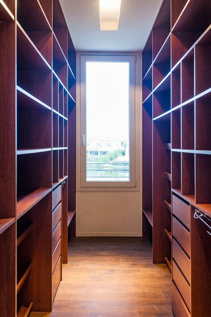 Vestidor moderno con mueblería de madera, iluminación led y vista panorámica — proyecto Racionalismo en Hormigón, por Ciba Arquitectura