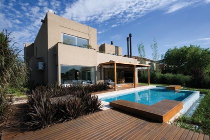 Casa contemporánea con pileta, deck de madera y pérgola en patio — proyecto Racionalismo Moderno, por Ciba Arquitectura