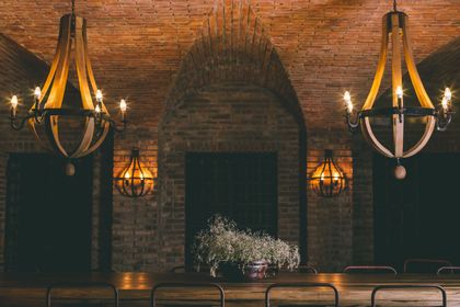 Comedor industrial con arco de ladrillo y lámparas colgantes de hierro — proyecto Rosell Boher Lodge , por Estudio Du 