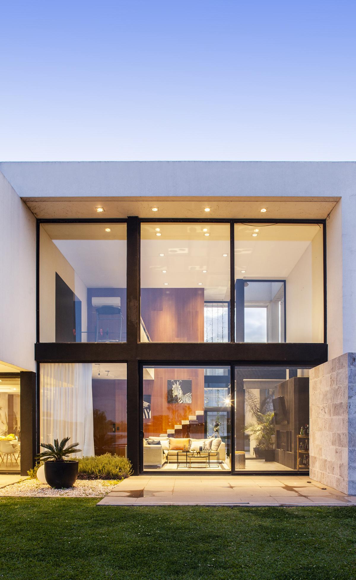 Fachada moderna com janelas do chão ao teto e escada flutuante — projeto Casa BJM, por Vanguarda Arquitectos, em Belén de Escobar
