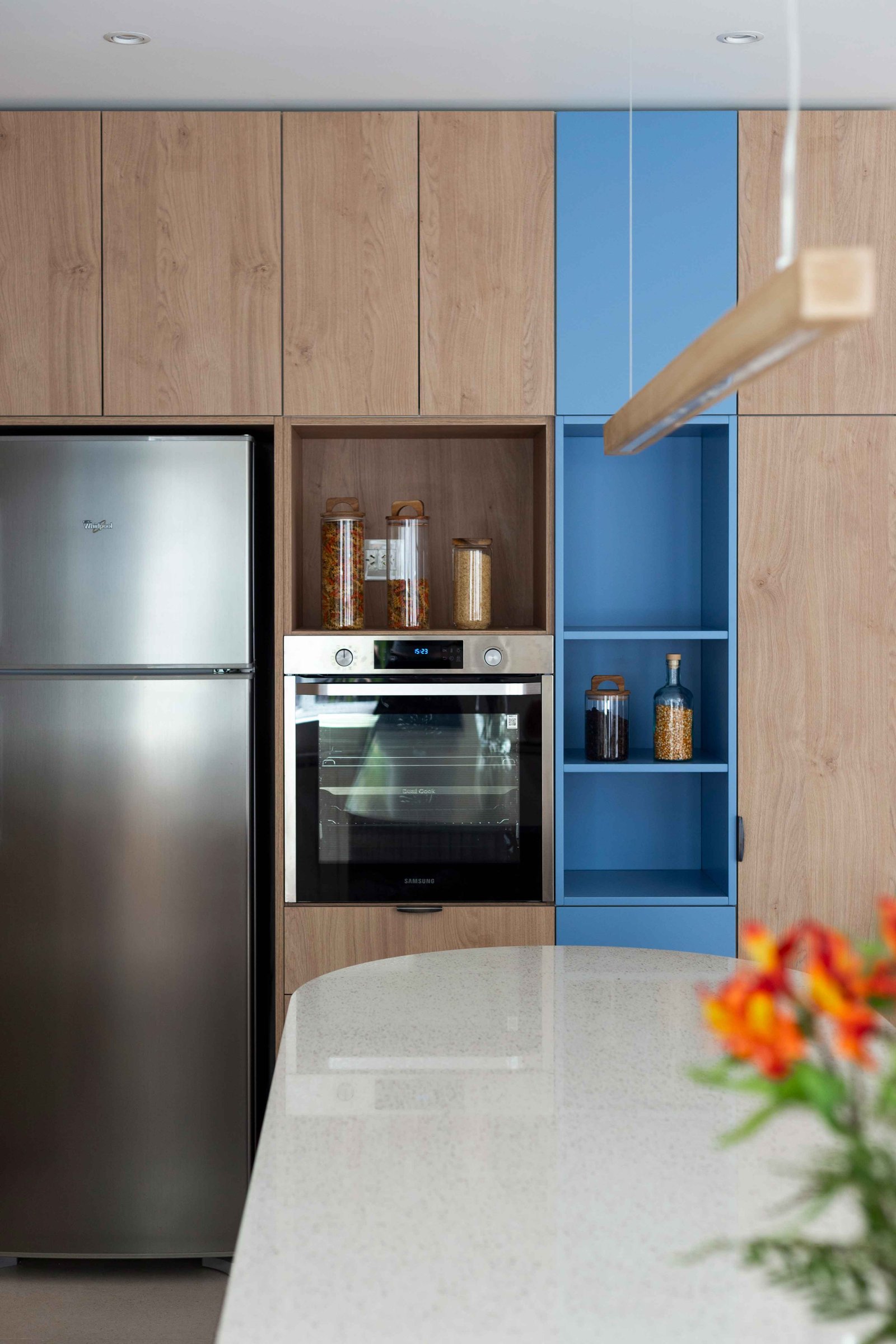 Cozinha escandinava moderna com armários de madeira e azul, geladeira e forno integrados — projeto Grecia, por Bouré Studio, em Núñez