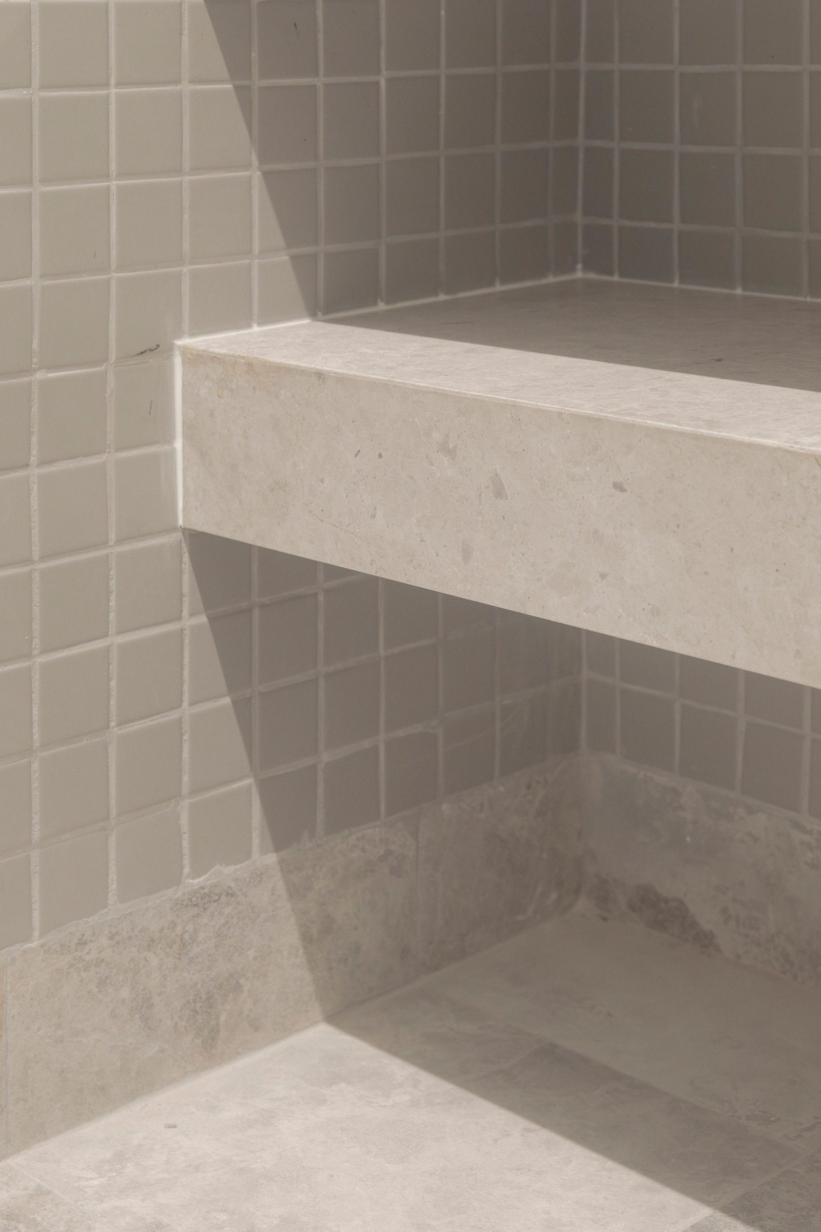 Baño moderno con azulejos grises y mesada de piedra clara — proyecto Reforma O'Higgins, por Estudio YME, en Belgrano