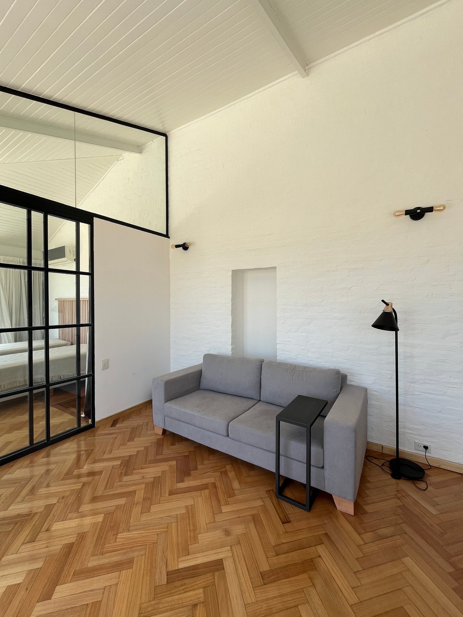 Living moderno de estilo industrial con techos altos y piso de madera — proyecto Departamento Puerto Madero, por Arcucci Arquitectura, en Puerto Madero