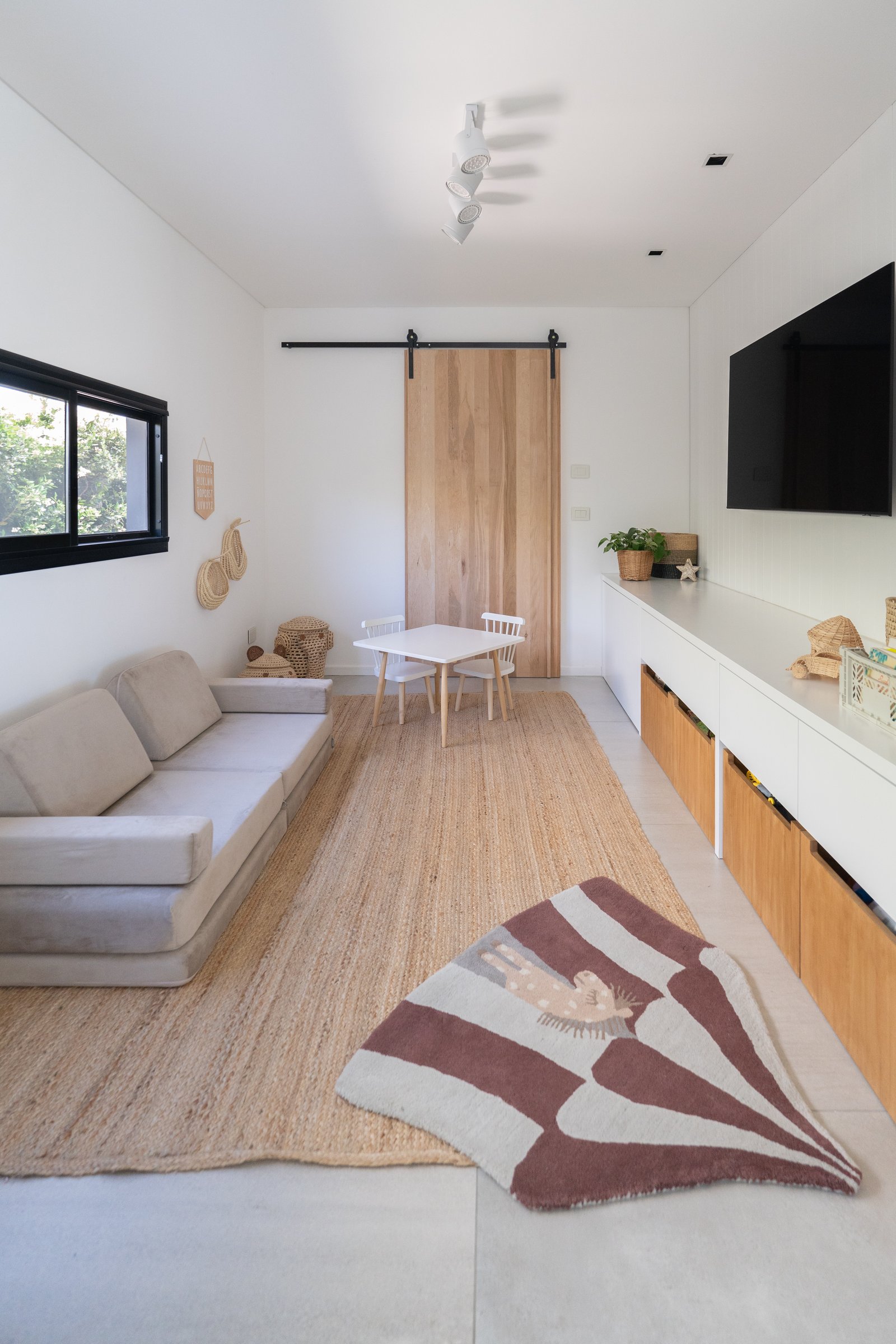 Sala de estar moderna com sofá modular e tapete de juta — projeto PROYECTO VISTAS, por July Acosta Home, em Belén de Escobar