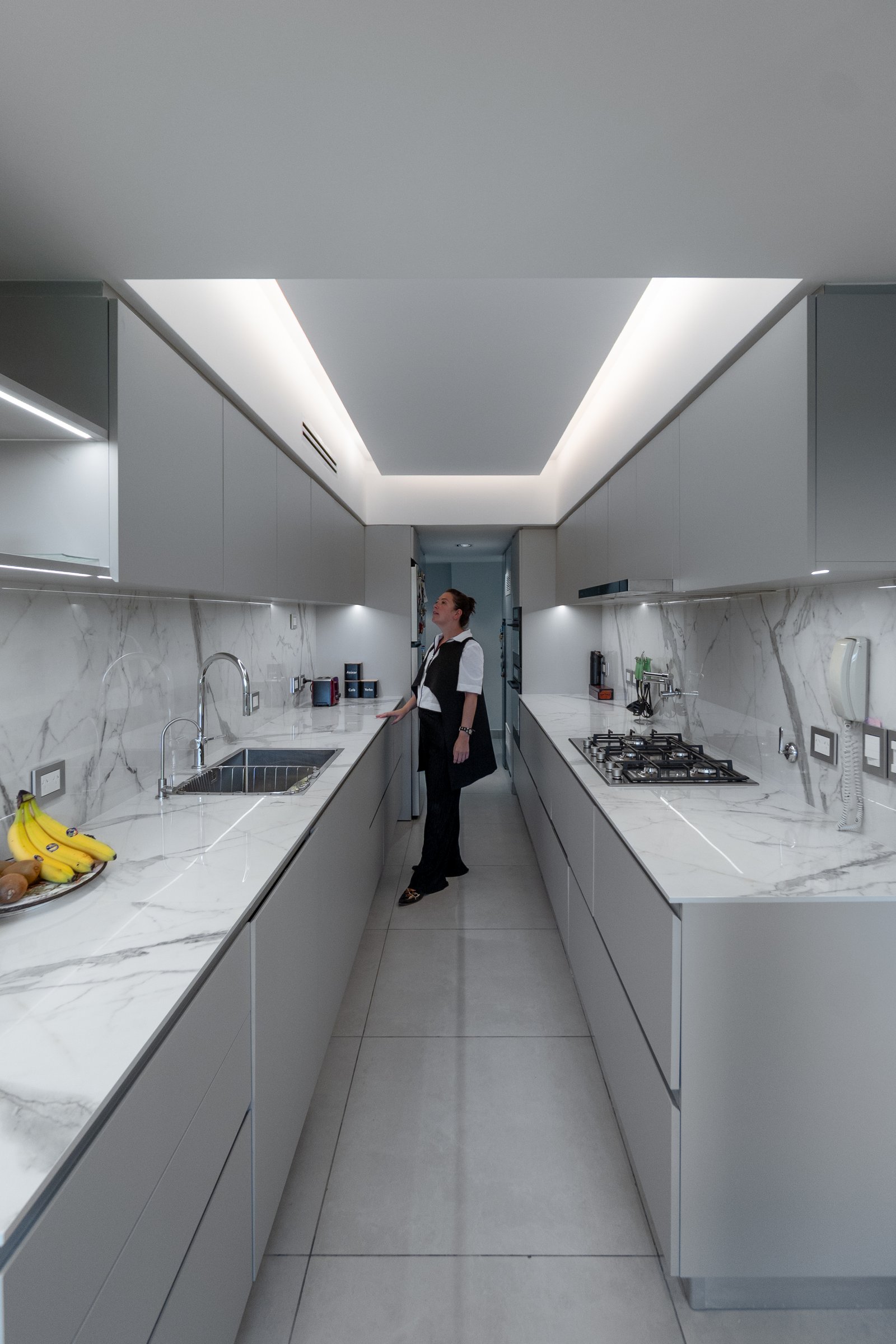 Cozinha moderna galley com mármore, iluminação zenital e minimalista — projeto Sucre, por KUPERDESIGN CONSTRUCCIONES SRL, em Mcal. Antonio José de Sucre 755