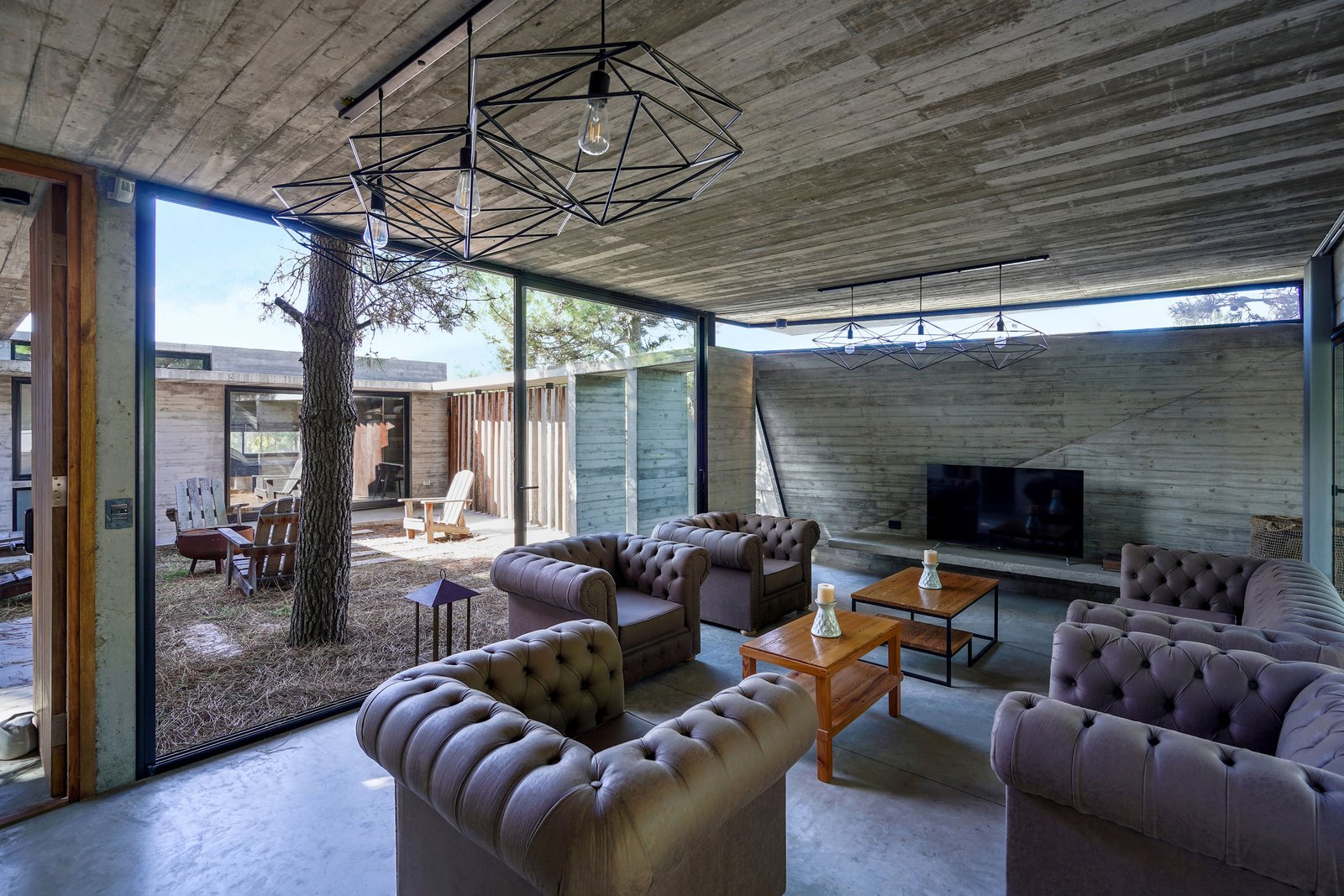 Living moderno con hormigón expuesto y madera — proyecto Casa Loma, por Besonías Almeida arquitectos, en X6VF+67
