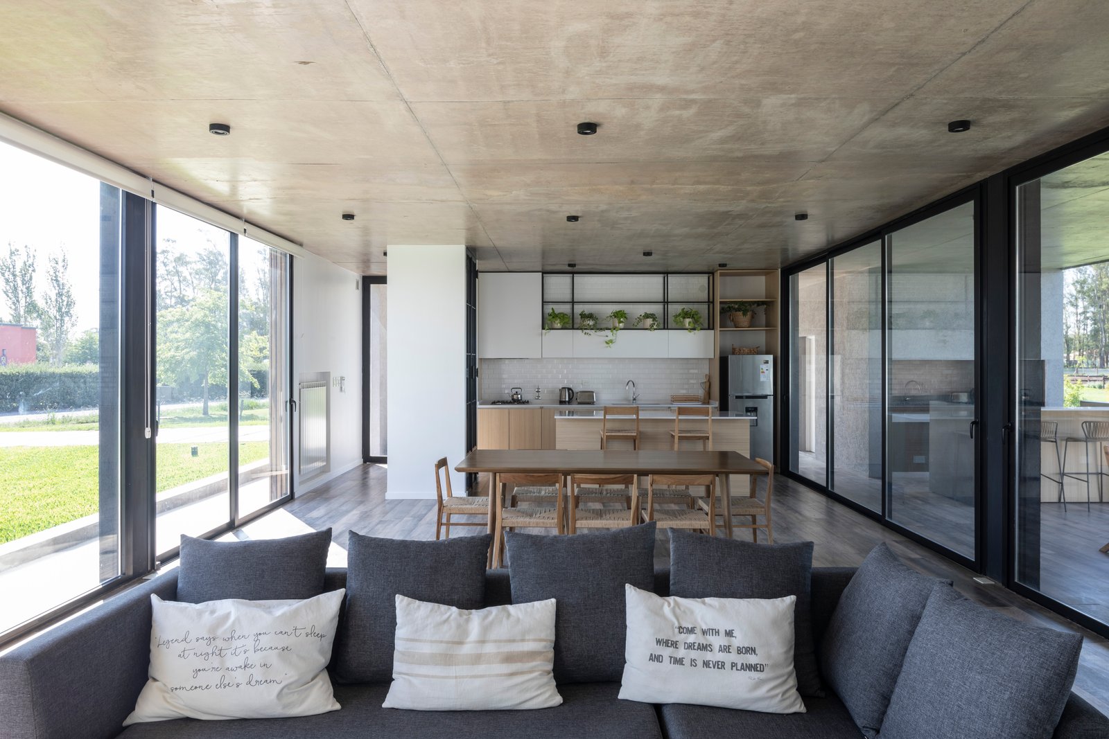Sala de estar moderna com cozinha integrada e teto de concreto aparente — projeto Casa Cruz, por Grupo CRBN, em B2812 Exaltación de la Cruz