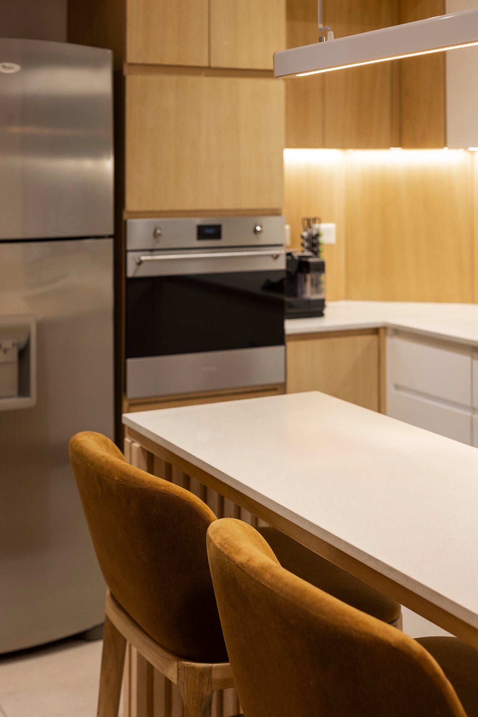 Cocina moderna escandinava con muebles de madera y sillas de terciopelo — proyecto BARRACAS, por La Nave Arq., en Barracas