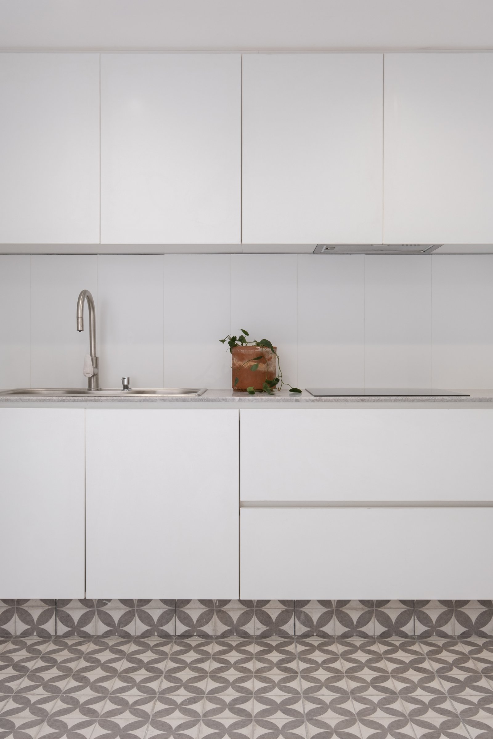 Cocina moderna minimalista con gabinetes blancos y azulejos geométricos — proyecto Casa Patio, por Herrera Ungaro, en San Cristóbal