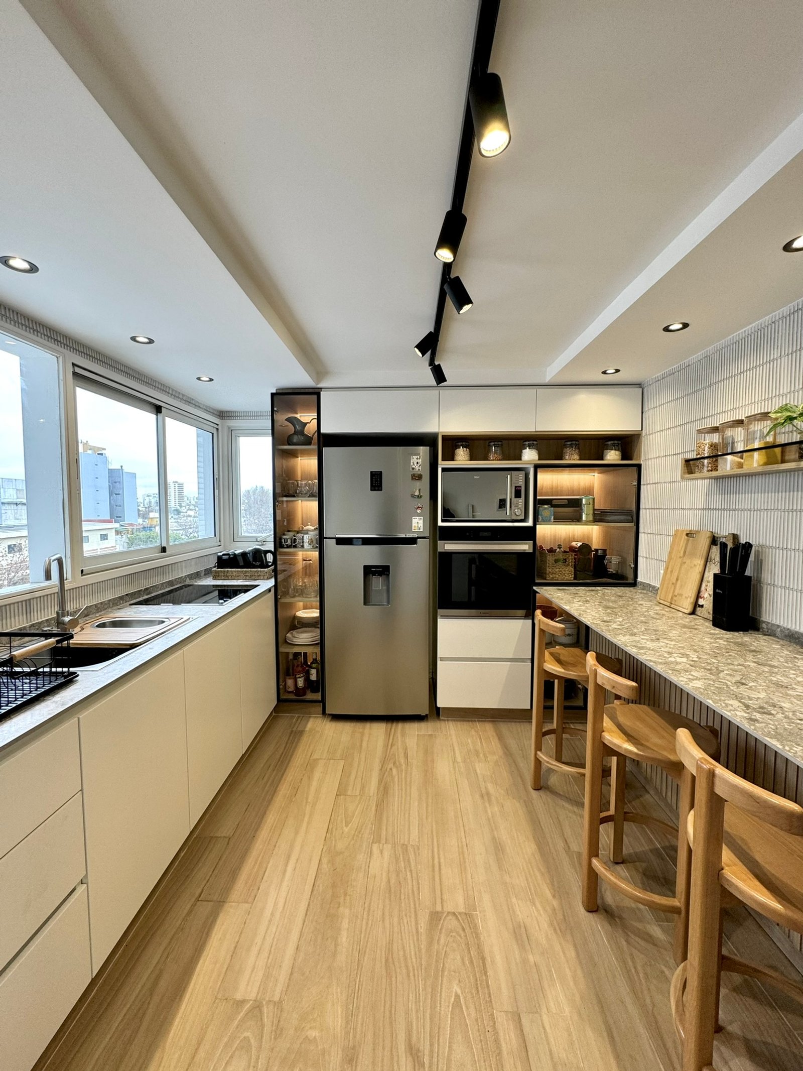 Cocina moderna minimalista con heladera de acero inoxidable y luz indirecta — proyecto Arengreen, por MDBK Arquitectura, en Caballito