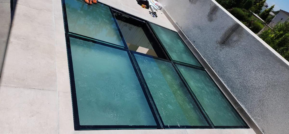 Fachada moderna en construcción con grandes ventanales de vidrio — proyecto Piso Opacid 30mm transitable, por Cristalcenter, en Canning