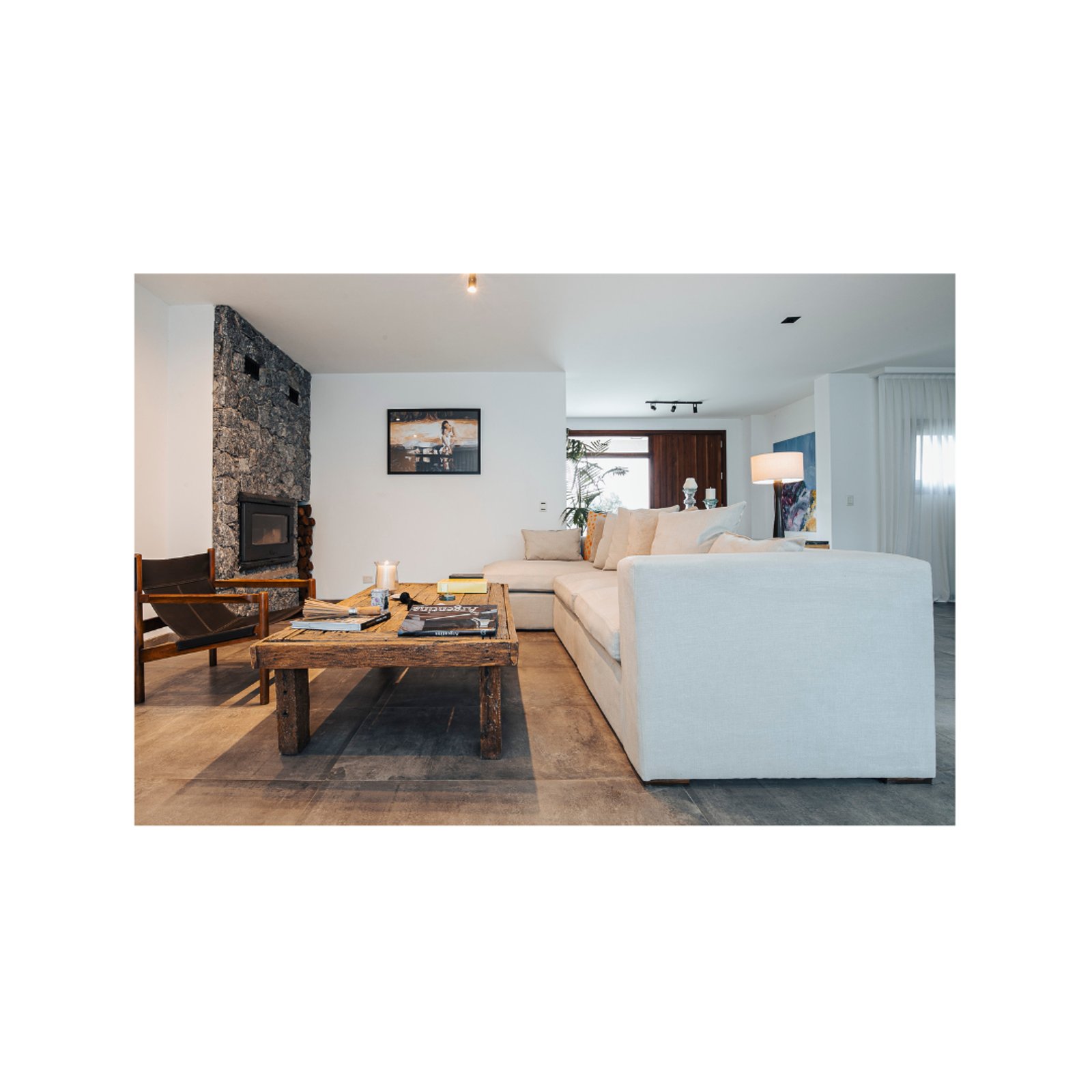 Sala moderna com lareira de pedra e sofá branco — projeto Casa Piedra, por Vero Julian Tendencias, em San Vicente