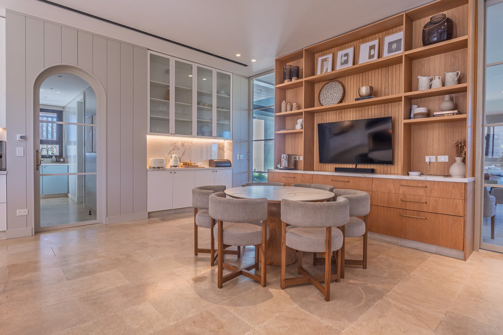 Comedor moderno con mesa redonda, sillas y estanterías de madera — proyecto Pilar A, por Josefina Bertora, en Los Cipreses 2
