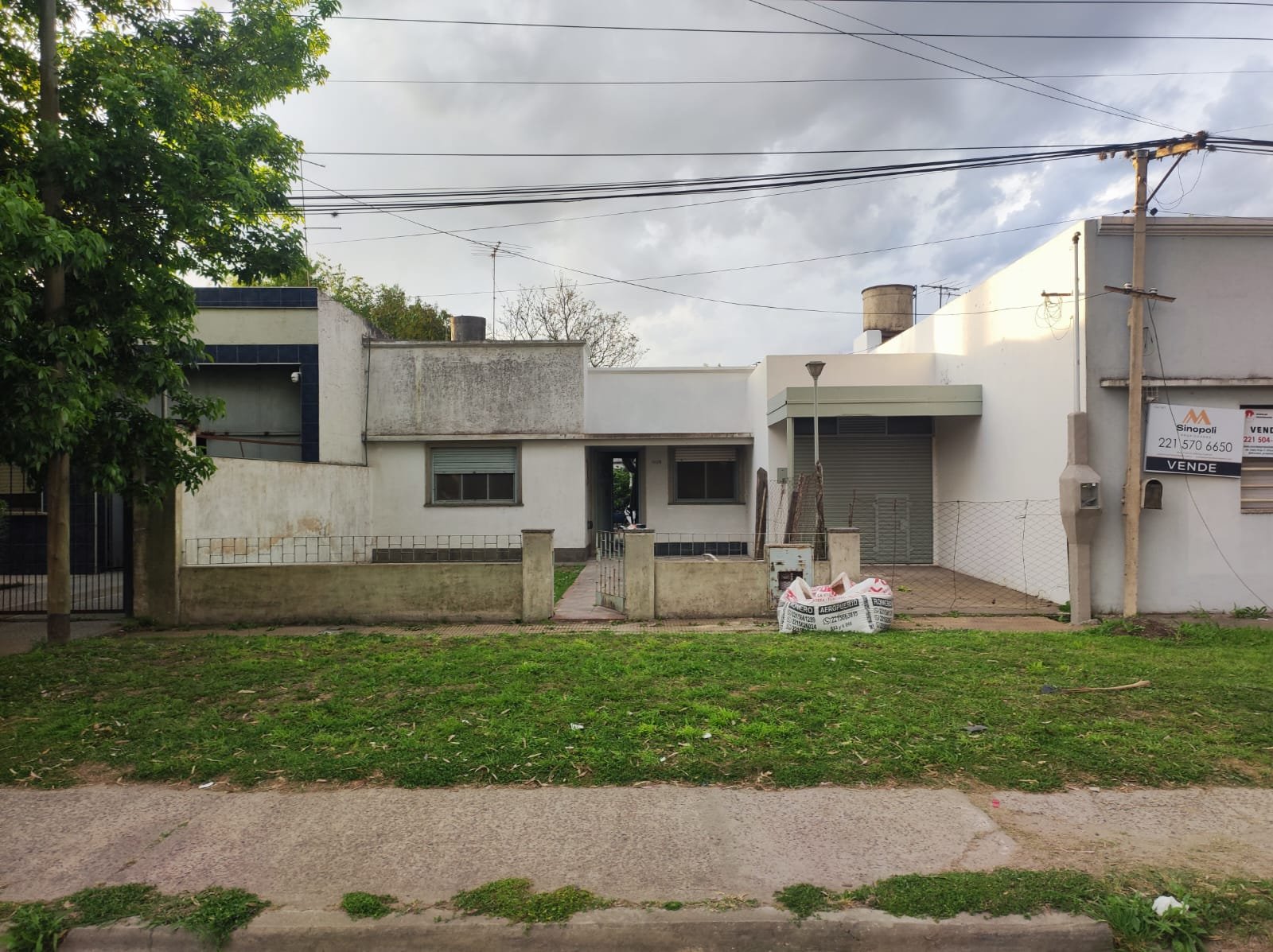 fachada de casa moderna com jardim e céu nublado — projeto REFORMA C520, por Estudio Llobet, em Melchor Romero
