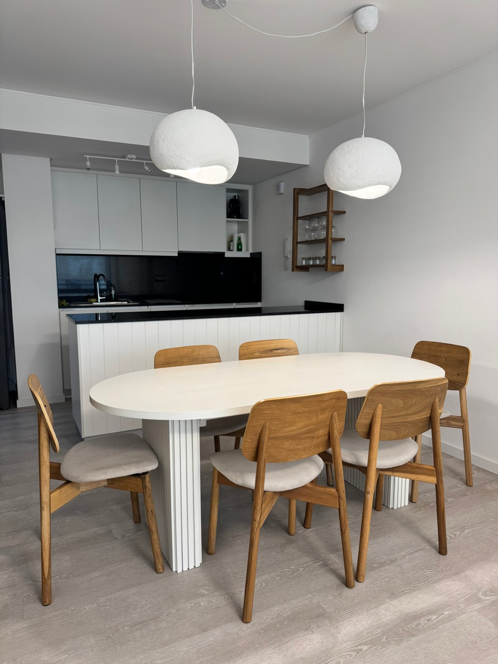 Sala de jantar moderna escandinava com pendentes orgânicos e mesa oval — projeto OM Botanico, por MDBK Arquitectura, em Palermo