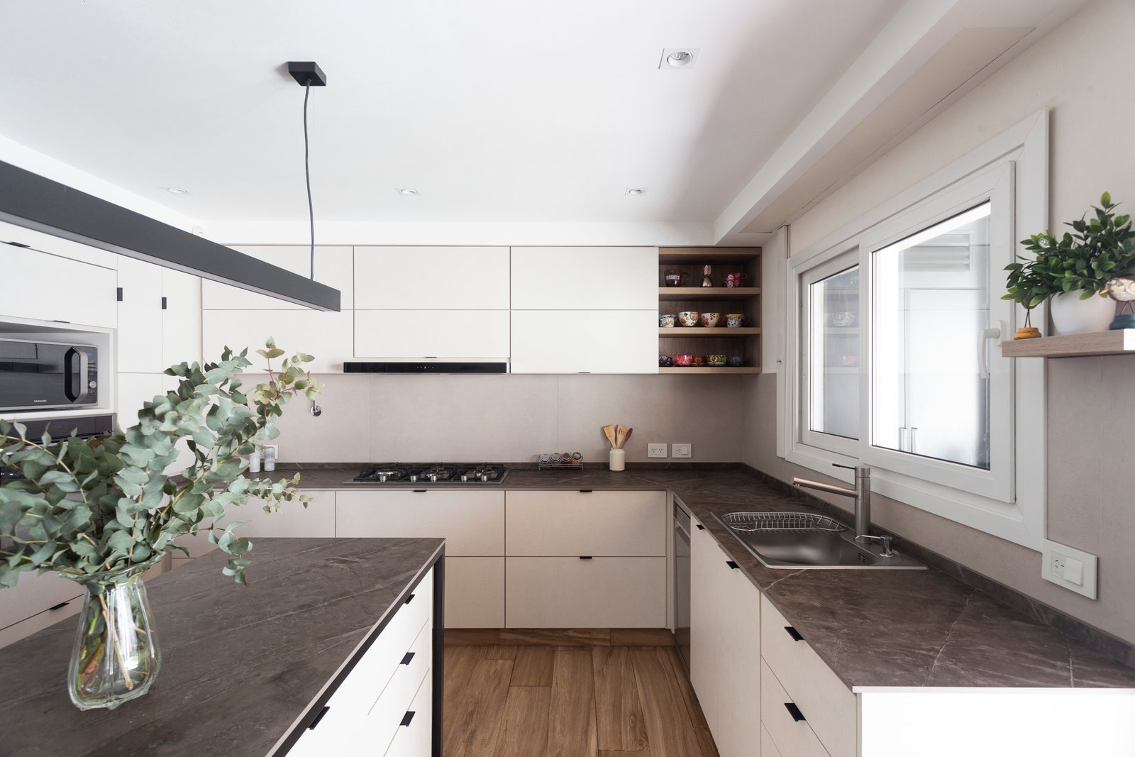 Cocina moderna blanca con isla de cascada y planta grande — proyecto Casa en Martinez, por JT ARQUITECTURA, en Martínez