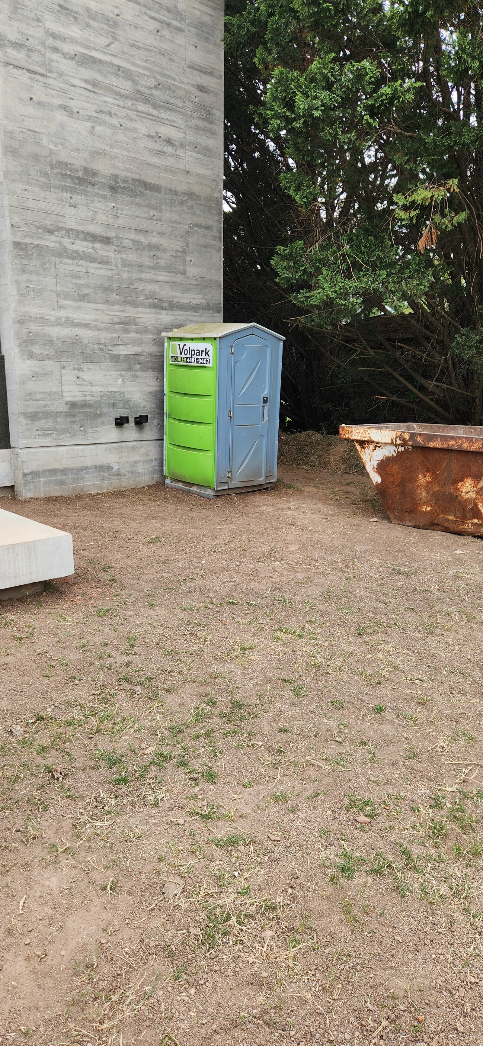 baño portátil al lado de muro de hormigón bruto — proyecto Casa CAD, por Estudio Rifahi, en Moreno