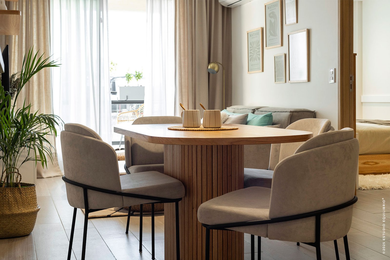 Sala de jantar moderna com mesa redonda de madeira e cadeiras bege — projeto Proyecto Nazca, por Estudio Equilibrio, em Villa Santa Rita