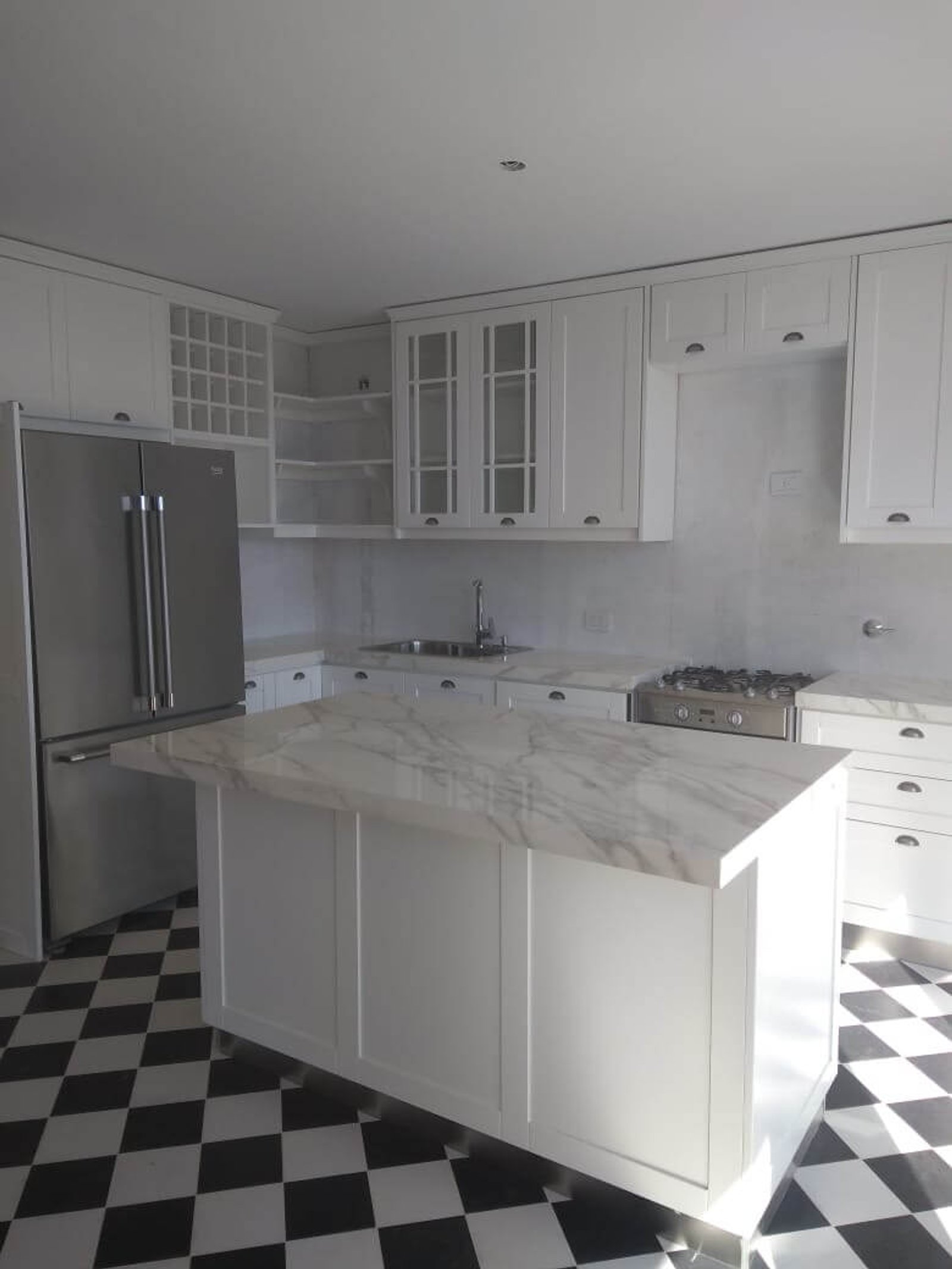 Cocina moderna con isla de mármol y piso damero — proyecto Línea Praga, por Casa Leiro