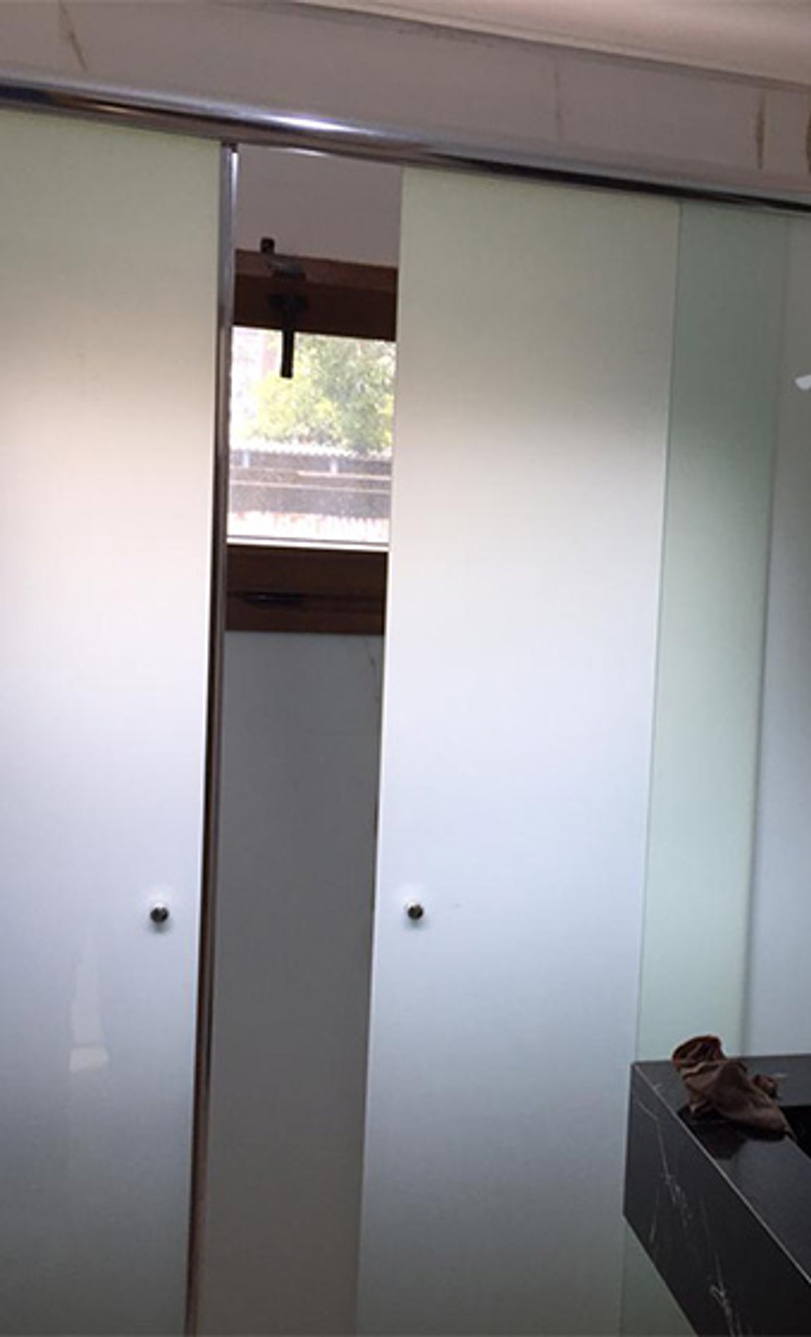 Baño moderno con puertas de ducha de vidrio esmerilado y encimera de mármol negro — proyecto Mamparas corredizas 8mm templado , por Cristalcenter, en Buenos Aires