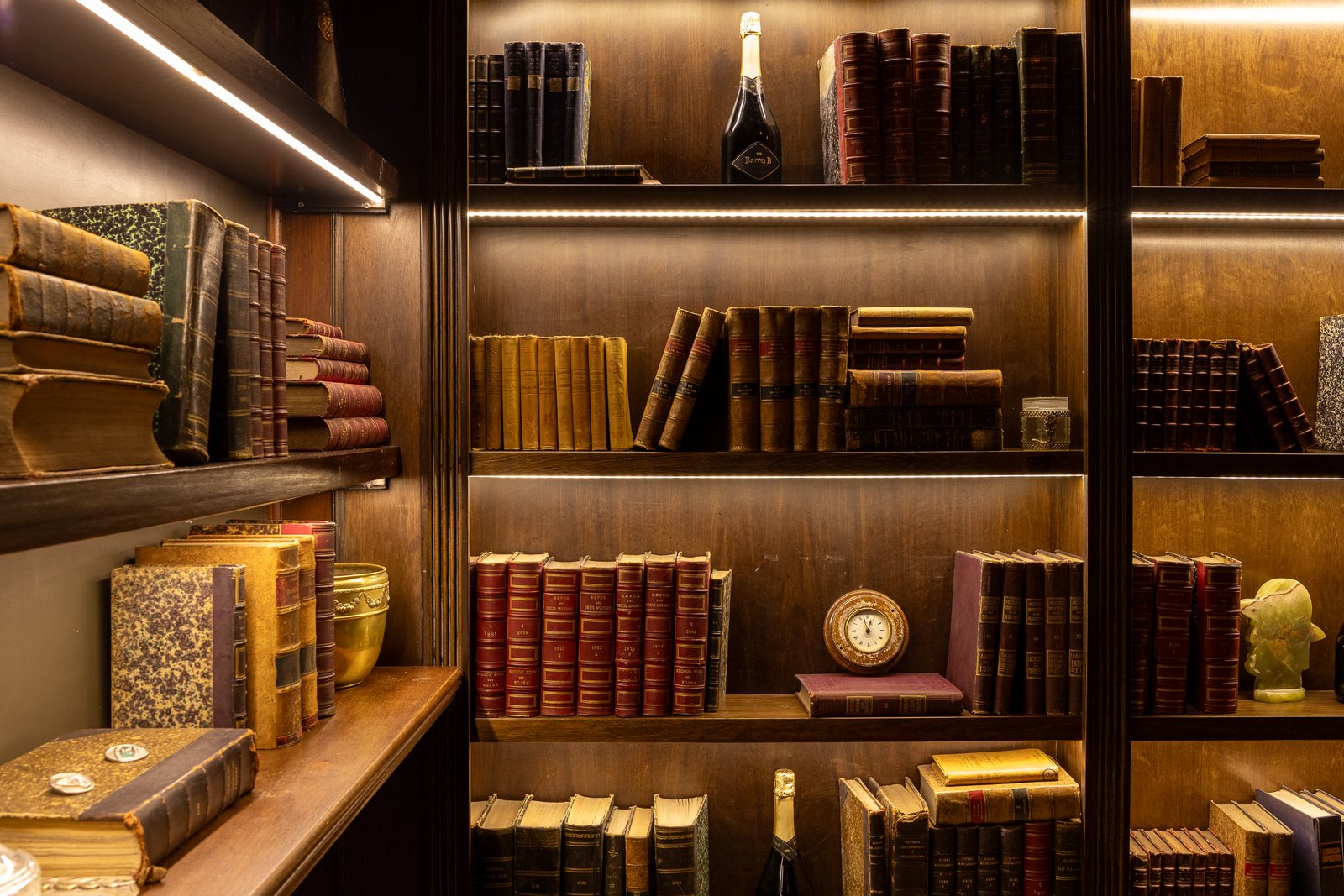 Estanterías de madera oscura hasta el techo llenas de libros — proyecto PRESIDENTE BAR HIPODROMO, por AB ARQUITECTURA, en San Isidro