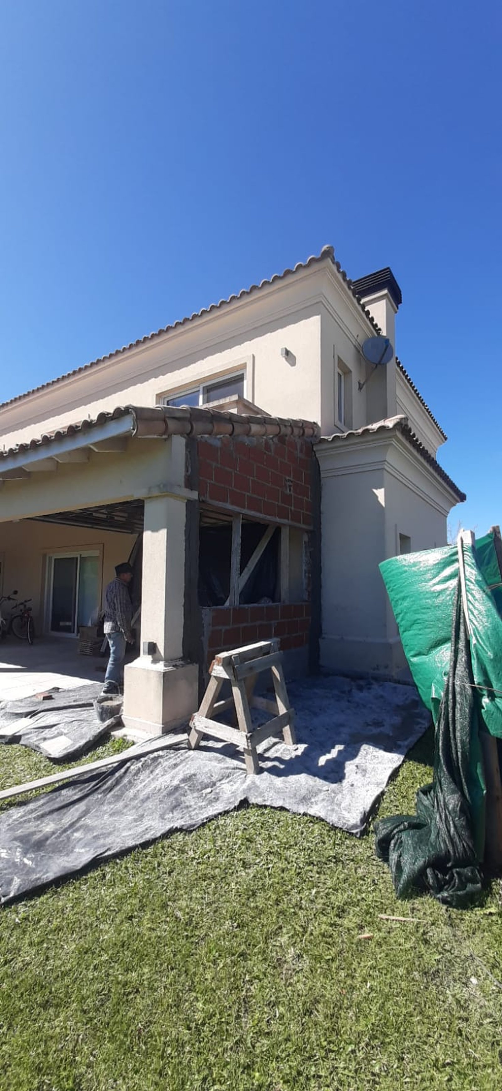 Casa en construcción con fachada mediterránea y ladrillos a la vista — proyecto Ampliación Residencial Barrio Terravista, por ODF Arquitectura & Obra, en Gral. Rodríguez