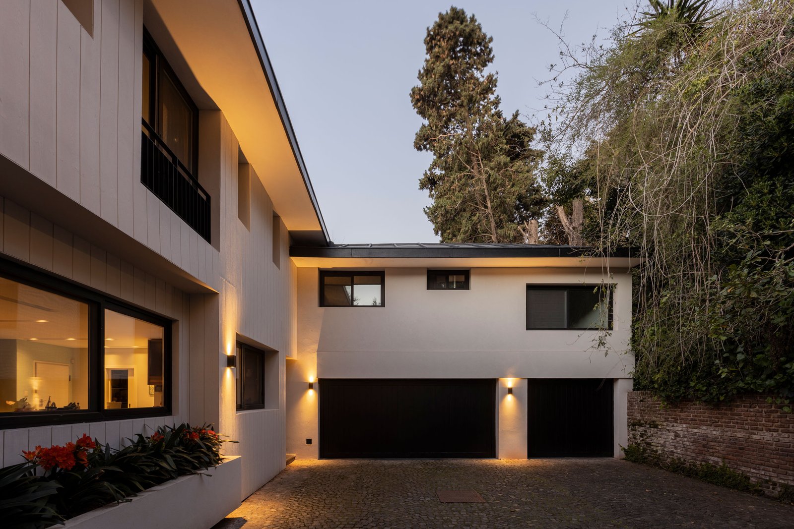 fachada de casa moderna con grandes ventanales negros — proyecto REFORMA DG, por Rastro Estudio, en Punta Chica