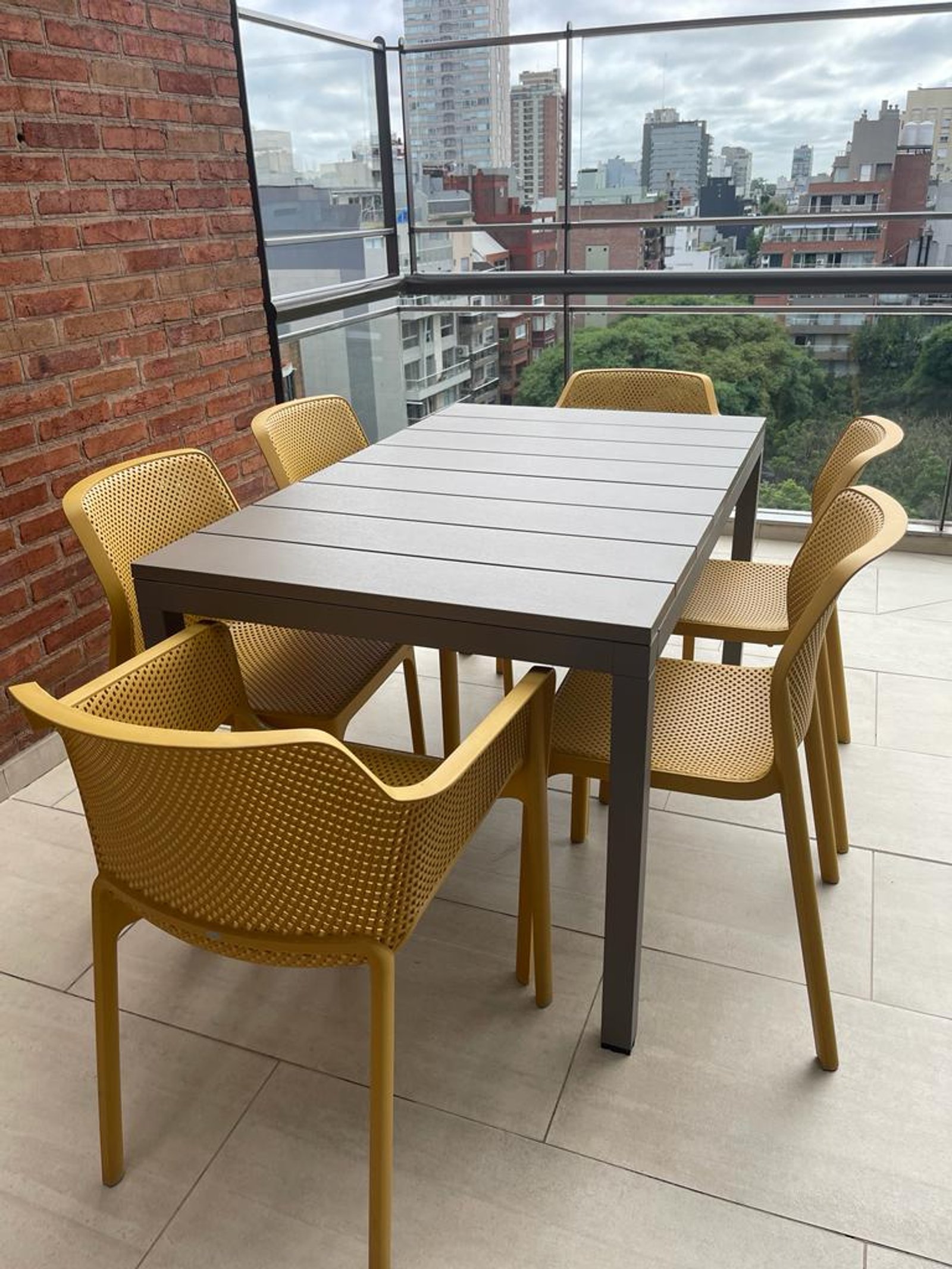 Comedor moderno en balcón con sillas amarillas — proyecto Comedor, por Casa Nuñez