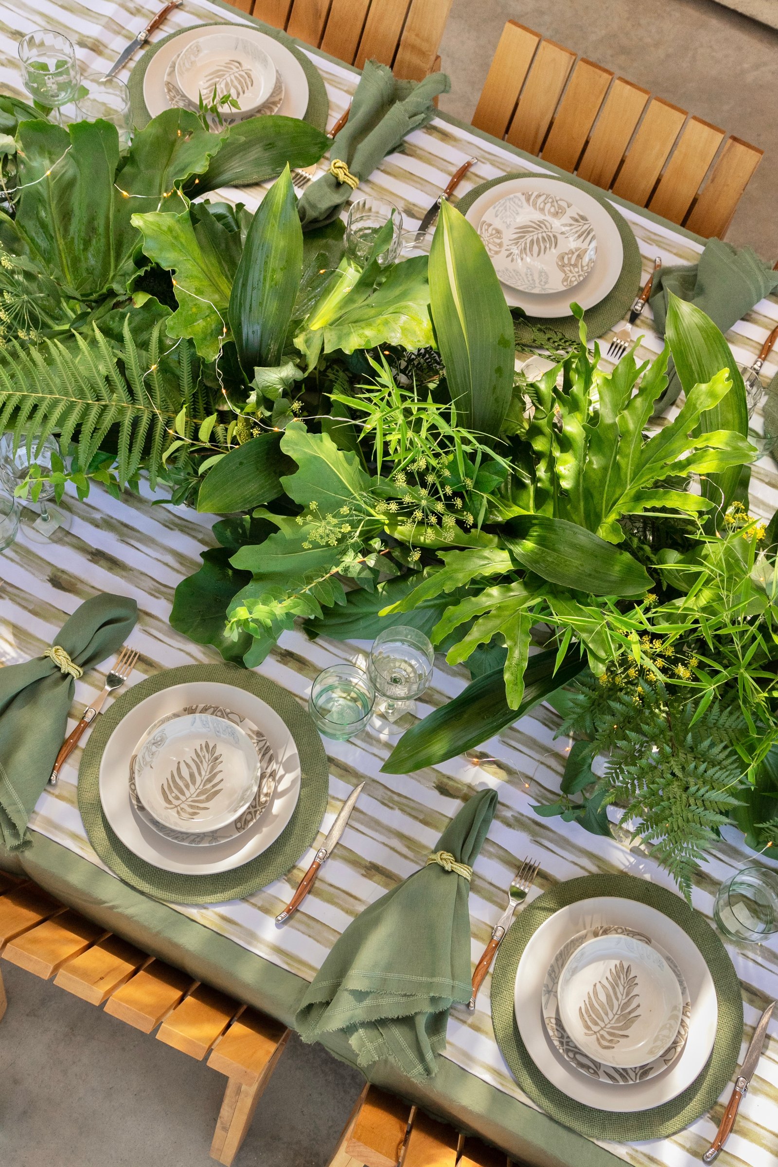 mesa externa com folhagem tropical e toalha listrada — projeto Styling, por El Marques deco y ambientaciones, em Córdoba