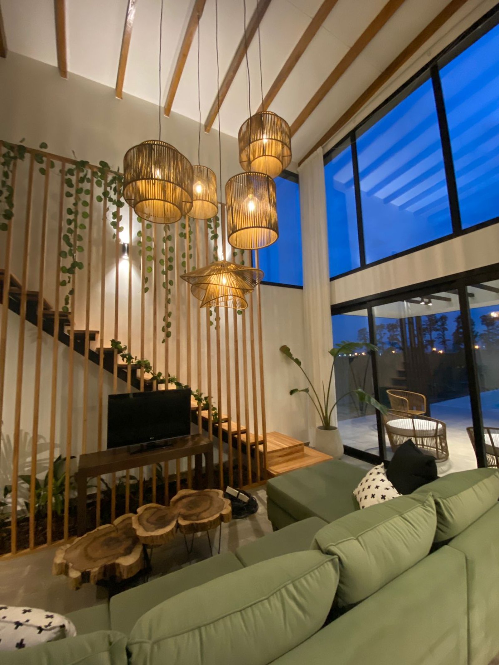 Sala de estar moderna estilo boho com luminárias de vime e escada — projeto Casa Tulum, por vetainteriores, em Pergamino