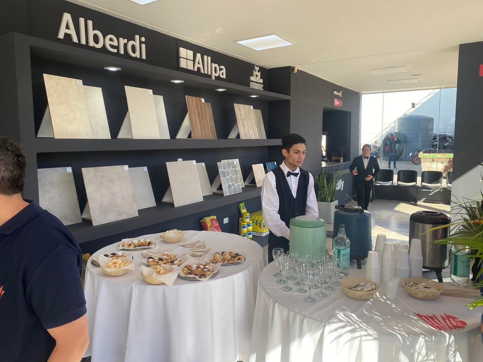 Salón comercial moderno con exhibición de madera y mesas de catering — proyecto Edify Casa central. Local de venta de materiales de Construccion., por Arquitecto Gustavo Maidana, e
