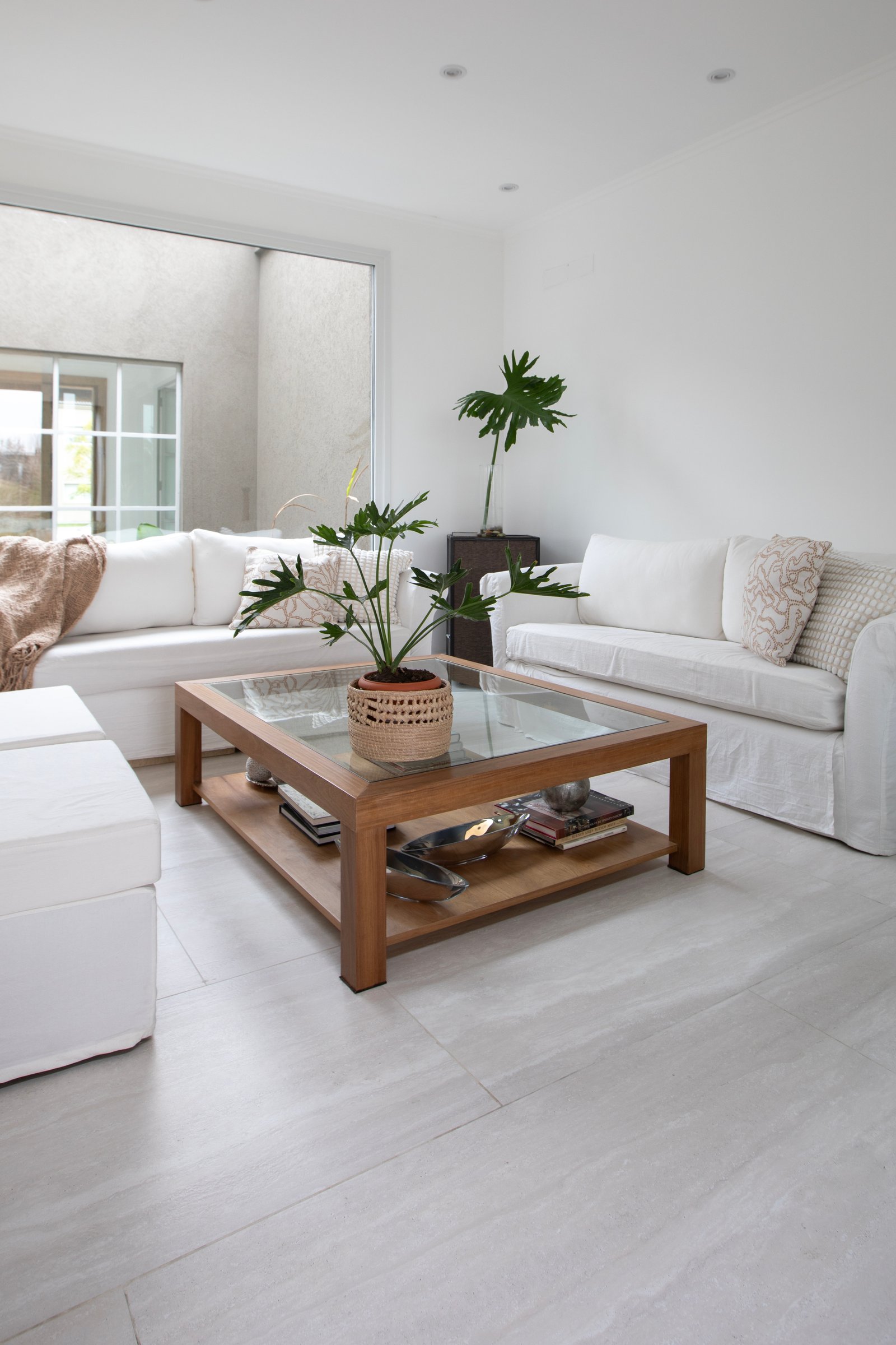 Sala moderna com sofás brancos e mesa de centro de vidro — projeto OBRA EL RETIRO, por ILVA, em Provincia de Buenos Aires