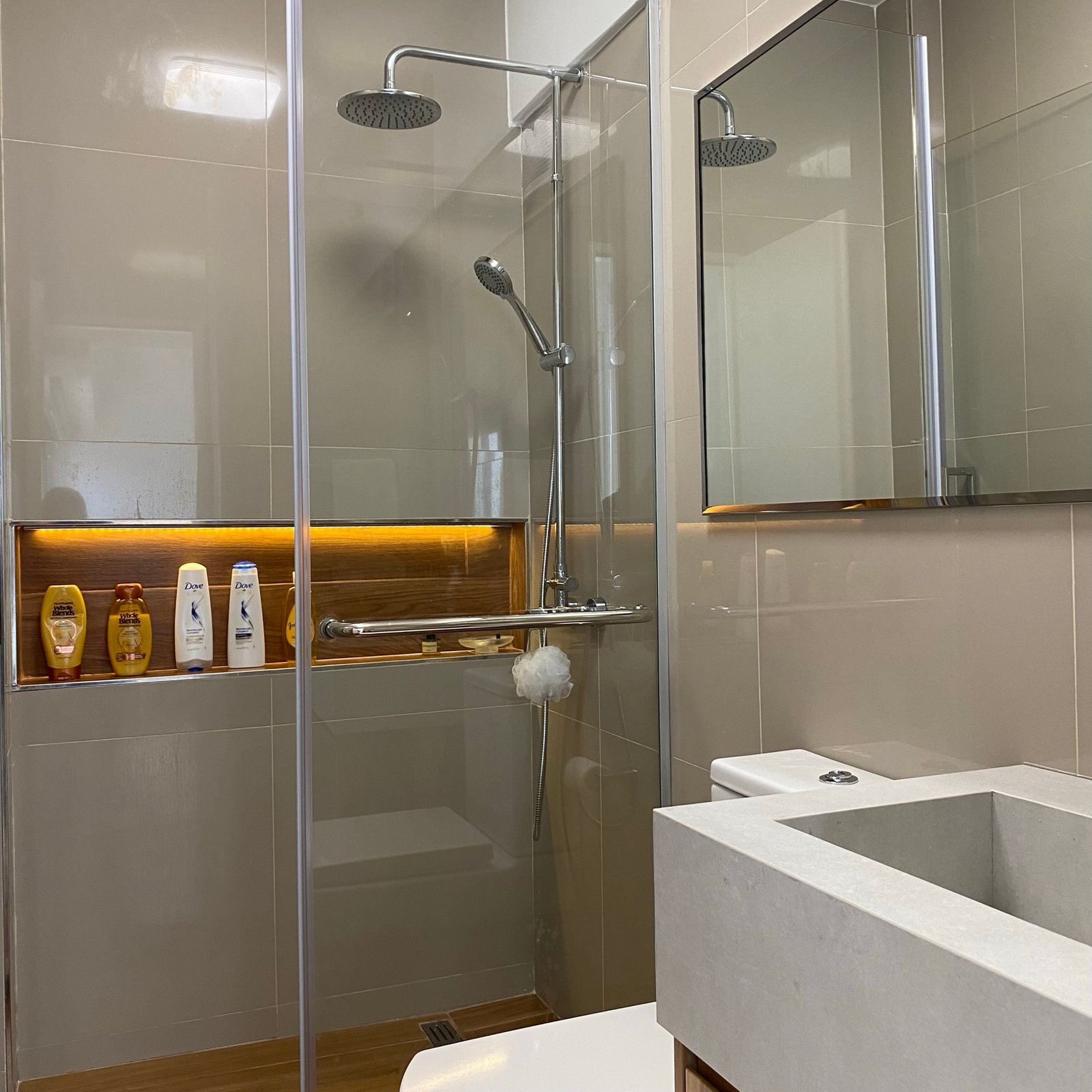 banheiro moderno com box de vidro e prateleiras de madeira — projeto Pringles, por MDBK Arquitectura, em Almagro