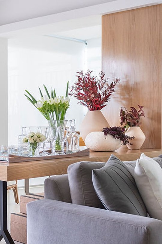 living minimalista con sillon gris, flores secas y espejo grande — proyecto Cobertura Panamby, por Bordin E Soares Interiores