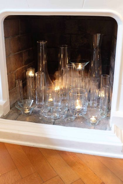 Detalle chimenea decorada con velas en botellas de vidrio — proyecto Santa Fe, por Estudio Diez Muzzio, en CABA