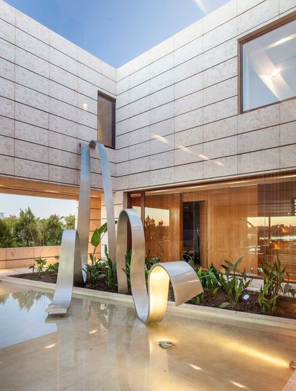 Patio moderno con esculturas metálicas y fachada vidriada contemporánea — proyecto Arquitectura de Autor, por Ciba Arquitectura
