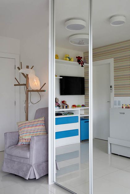 Dormitorio minimalista con espejo, sillón y vestidor integrado con frentes azules — proyecto Casa Blue House, por Amanda Miranda