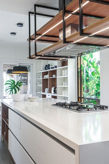 Cocina moderna con isla, techo de madera y acero negro, plantas — proyecto Casa Nordelta, por Gutman+Lehrer Arquitectas, en Nordelta