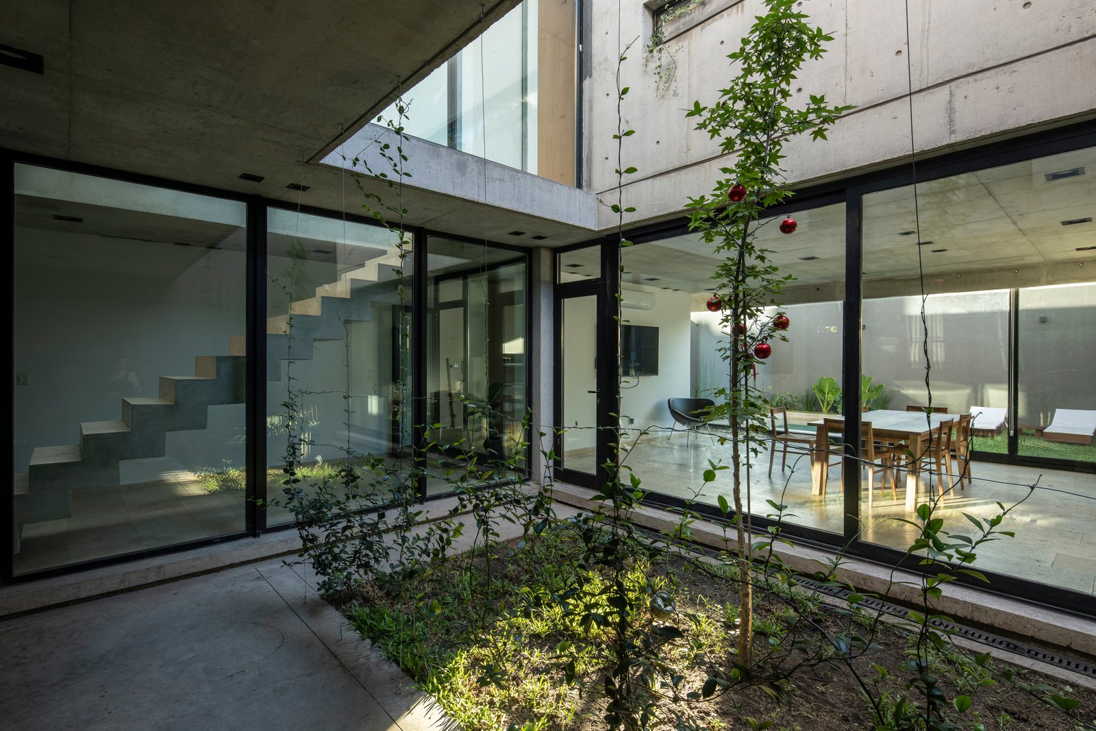 Área externa moderna com jardim interno e sala de estar — projeto Casa MECHA, por Grupo CRBN, em B1712 Castelar