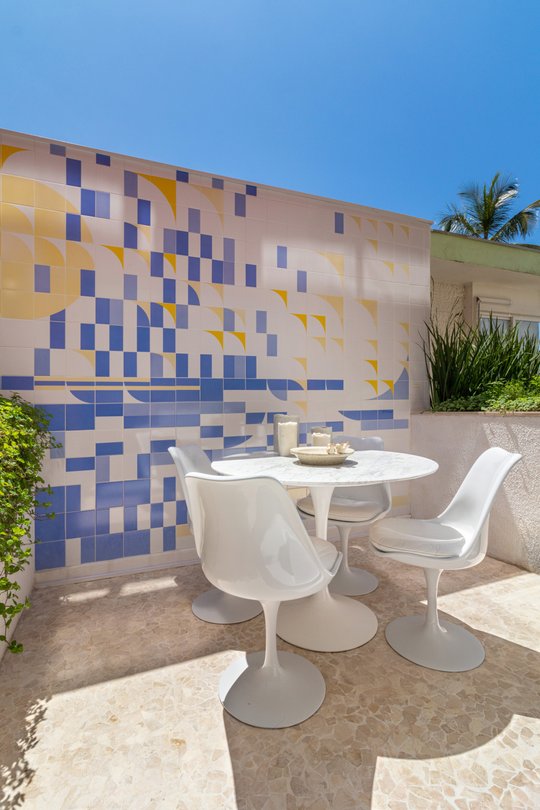 Terraza comedor con mural de azulejos geométricos y muebles tulip blancos — proyecto Residencial, por  Rodolfo Fontana