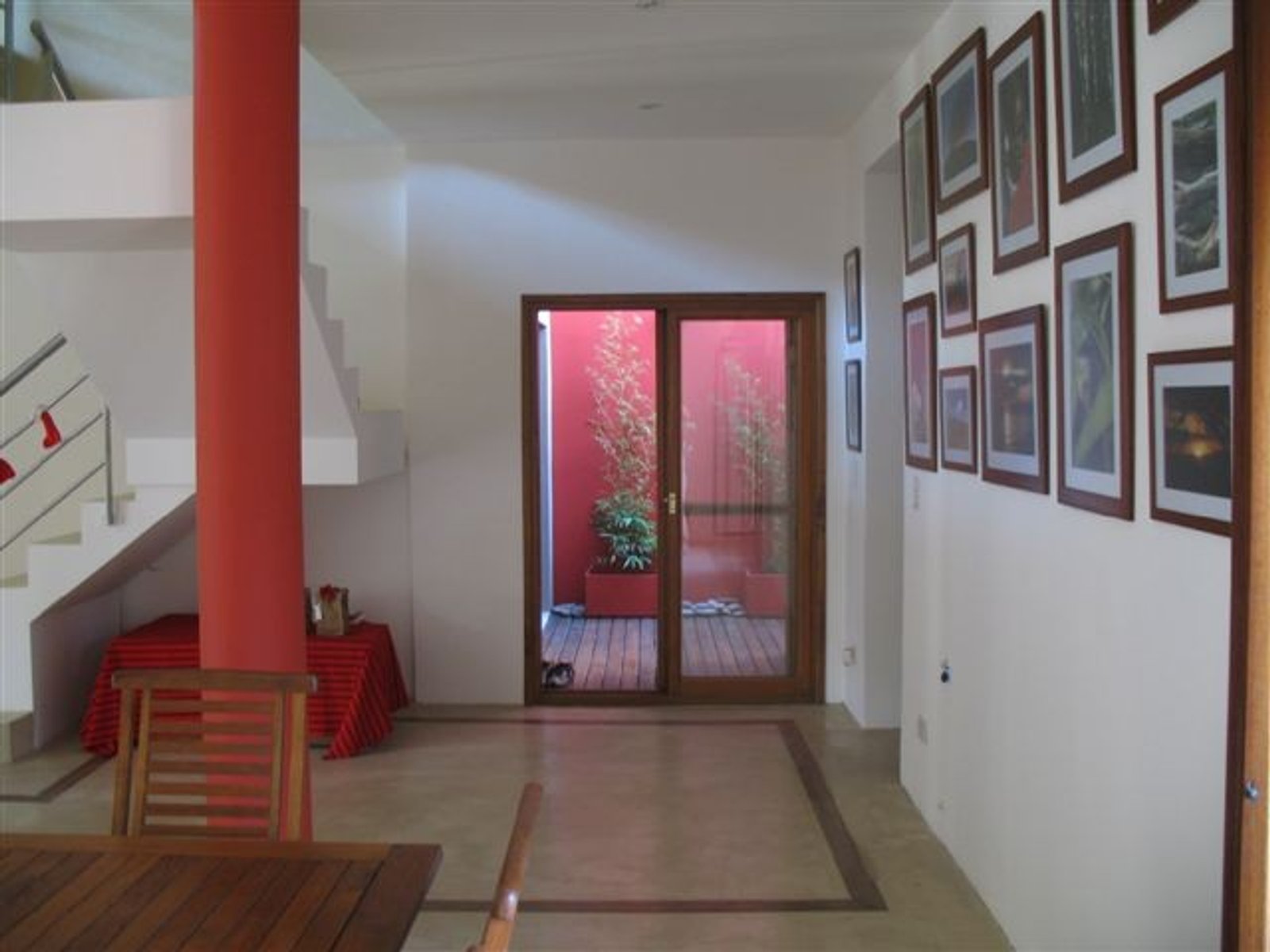 Pasillo moderno con patio interior y columna roja — proyecto Departamento CABA, por PROTEX, en Buenos Aires