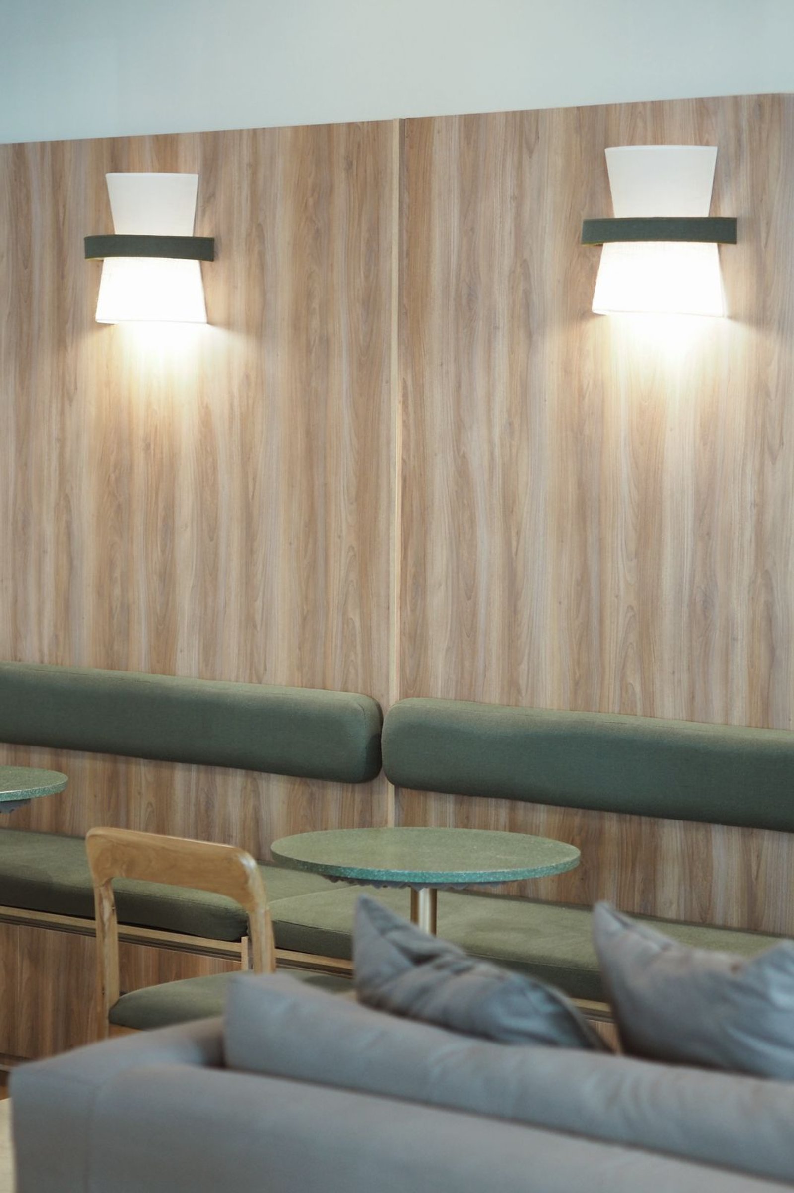 Espaço interno com painéis de madeira, assentos tipo 'booth' e iluminação moderna — projeto FOMO CAFÉ, por APATHEIA, em Vicente López