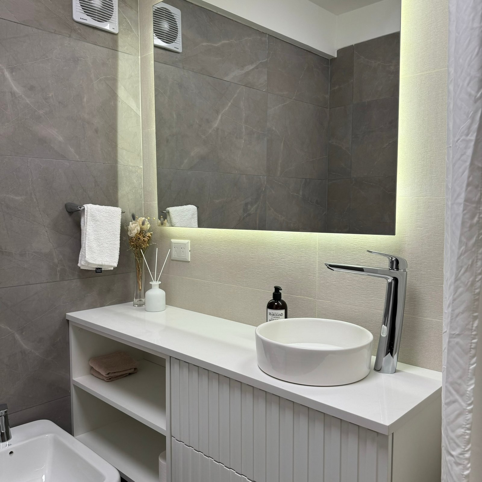 Baño moderno con mueble blanco acanalado y espejo retroiluminado — proyecto Arce, por MDBK Arquitectura, en lavalle 2501