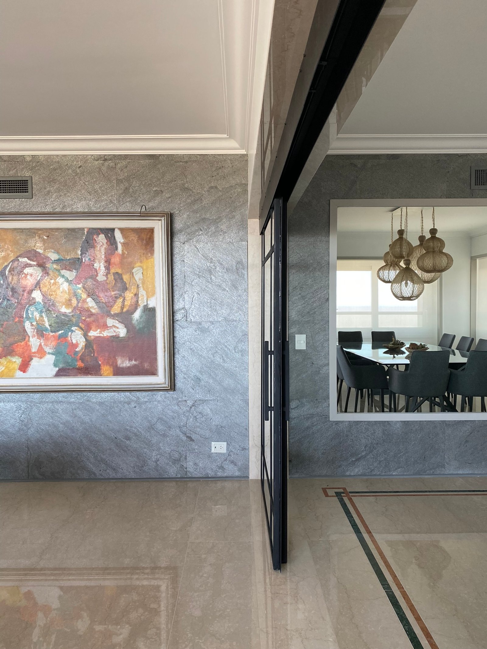 Pasillo moderno con pared de piedra texturizada y pintura abstracta — proyecto Libertador I, por MDBK Arquitectura, en Palermo