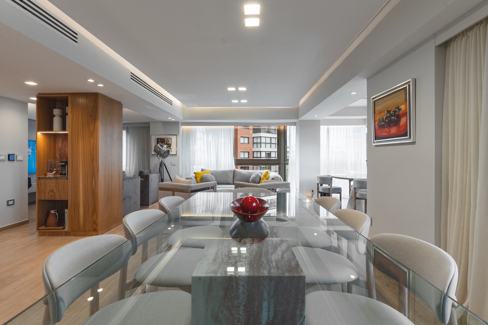 Sala de jantar moderna aberta para living, mesa de vidro e cadeiras cinzas — projeto Sucre, por KUPERDESIGN CONSTRUCCIONES SRL, em Mcal. Antonio José de Sucre 755