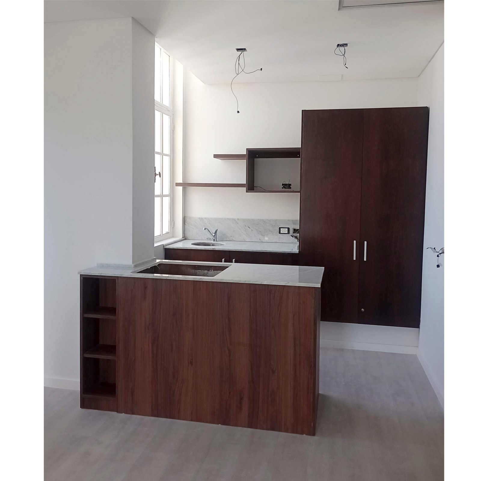 Cocina moderna abierta con isla de madera oscura y acabados minimalistas — proyecto PH Moreno II, por ASIA - arquitectura, en San Telmo