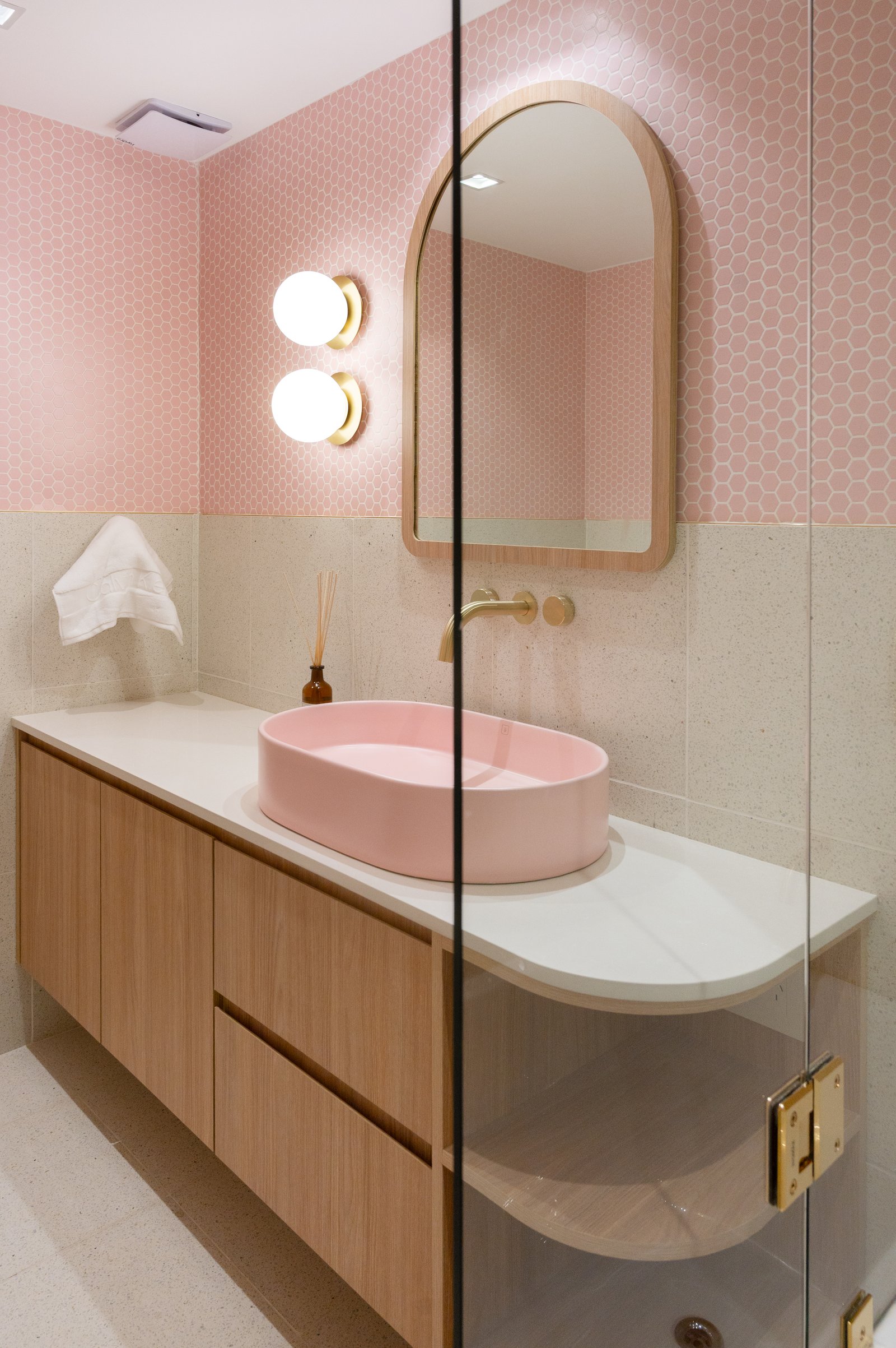Baño moderno con bacha rosa, muebles de madera y detalles dorados — proyecto ALVEAR TYM, por AB ARQUITECTURA, en Recoleta
