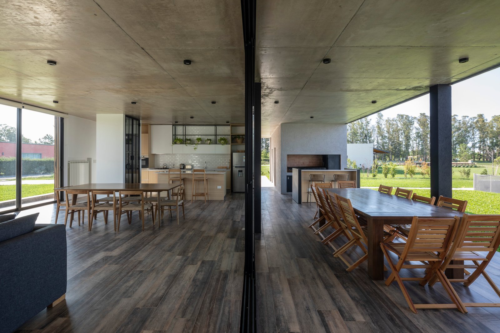Sala de jantar moderna ao ar livre com cozinha integrada e teto de concreto — projeto Casa Cruz, por Grupo CRBN, em B2812 Exaltación de la Cruz